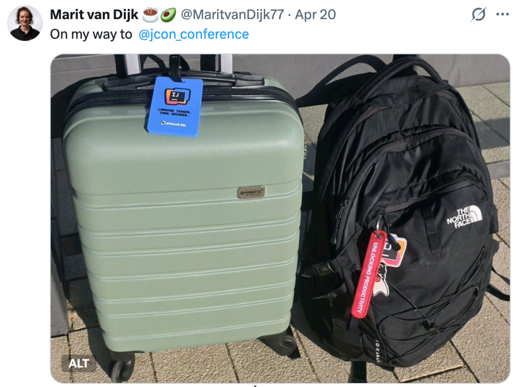 Social media post by Marit van Dijk with the text "On my way to JCON". The post contains a picture of a green suitcase with a luggage label containing the IntelliJ IDEA icon and the text "Luggage tagged. Code secured. JetBrains IDEs", and a black North Face backpack containing a red label with the text "Unlocking productivity", a tag of the IntelliJ IDEA logo, and a tag with Duke, the Java mascot.